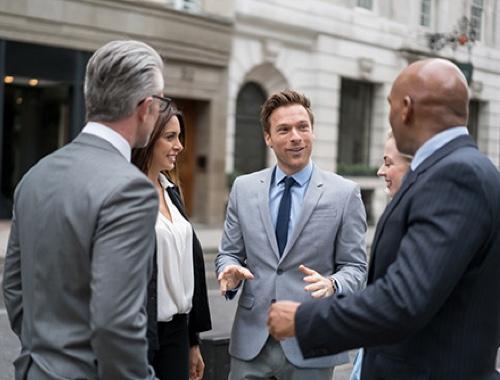 Financial professionals speaking together outdoors