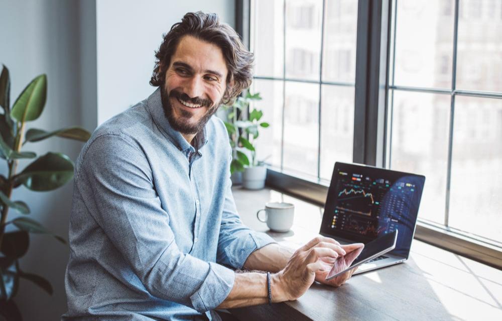 A business owner reviewing charts on a laptop and tablet